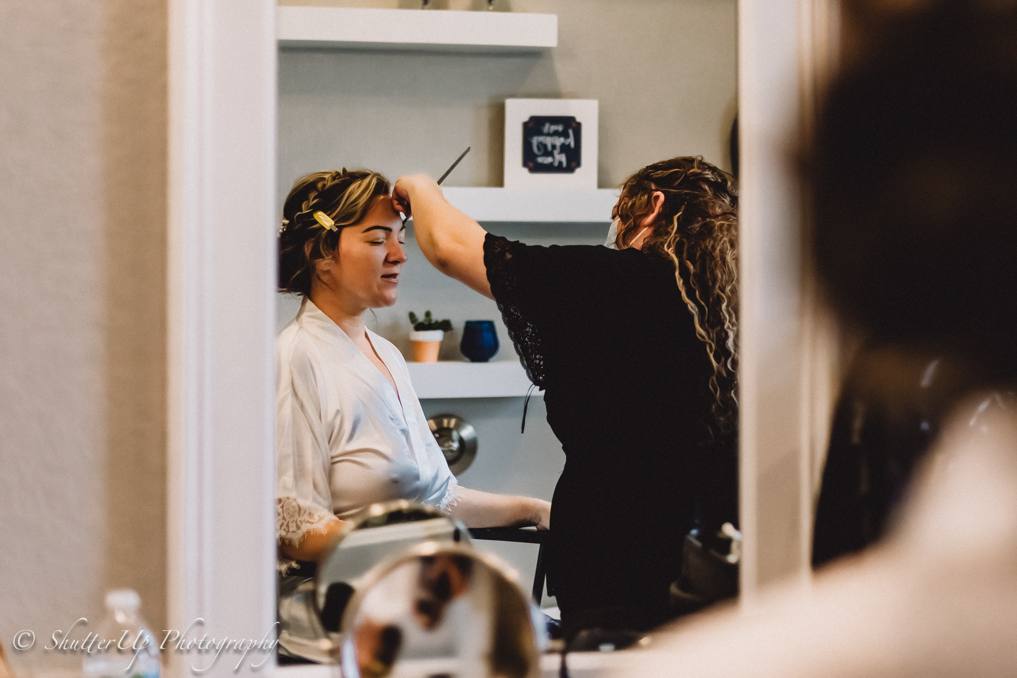 Photo of bride getting her makeup done.