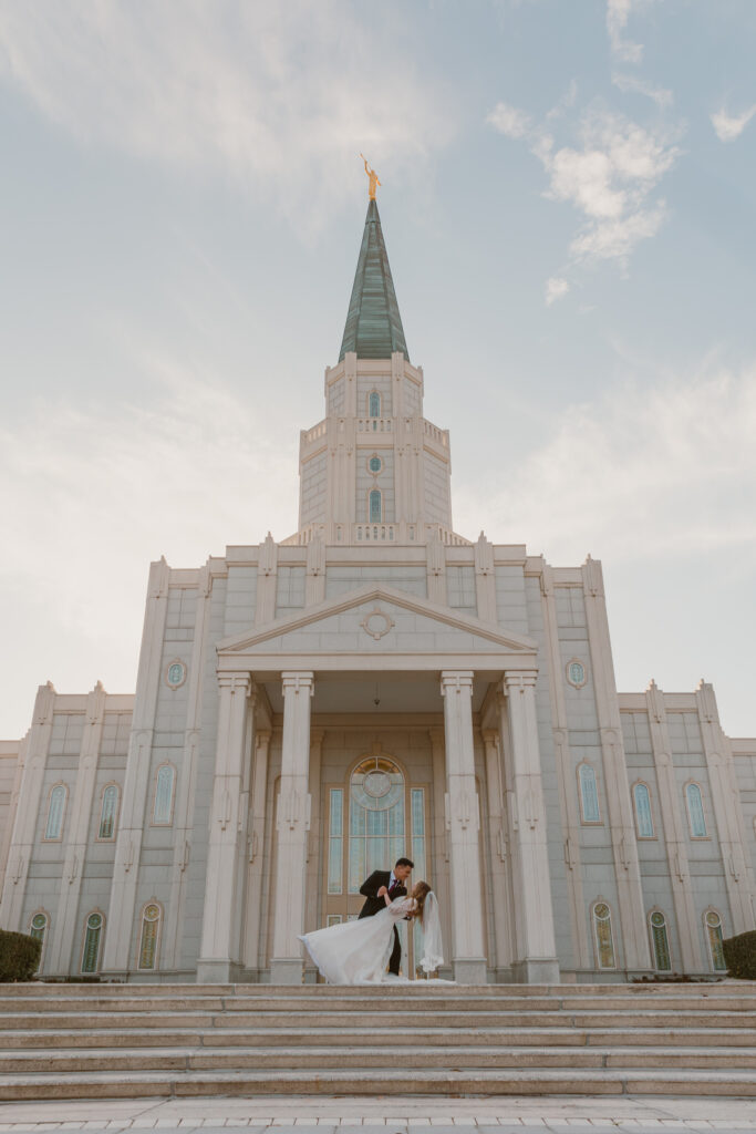 recently married bride and groom doing a dip pose in fount of the Houston temple 